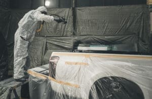 spraying bedliner on truck bed using high pressure spray equipment